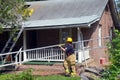 Firefighter carries a ladder outside a house