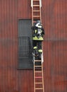 firefighter climbs the ladder with the oxygen cylinder during a Royalty Free Stock Photo