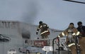 Firefighters climb a ladder truck to get a better position On fighting the fire at a warehouse in Hyattsville, Marylanda