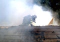 Firefighter covered in smoke as he crawls on the roof r