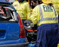 A firefighter cuts open a wrecked car with a tool known as The Jaws Of Life