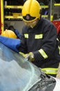 Firefighter cutting away a windscreen at car crash Royalty Free Stock Photo