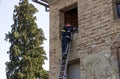 Firefighter on duty climbs the ladder to enter the window Royalty Free Stock Photo