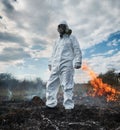 Firefighter ecologist in gas mask working in field with wildfire. Royalty Free Stock Photo