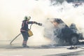 A firefighter extinguishes a car with a fire extinguisher. Fire extinguisher extinguishes a burning car from a fire hose Royalty Free Stock Photo