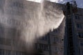 Firefighter extinguishes a fire in an apartment building from the height of a fire crane