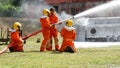 Firefighter fighting with flame using fire hose chemical water foam spray engine. Fireman wear hard hat, body safe suit uniform Royalty Free Stock Photo