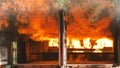 Firefighter fighting with flame using fire hose chemical water foam spray engine. Fireman wear hard hat, body safe suit uniform Royalty Free Stock Photo