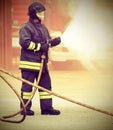 Firefighter during fire extinguishing and old toned effect Royalty Free Stock Photo