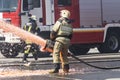 Firefighter - Firemen extinguishing a large blaze, they are standing with protective wear against the background of fire truck Royalty Free Stock Photo