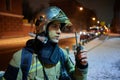 A firefighter in full gear, wearing a helmet with a protective glass visor, during a firefighting exercise at night