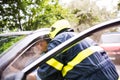 A firefighter getting an unconscious man out of the car after an accident.