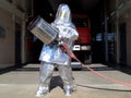 A firefighter in a shiny heat-reflecting suit to protect against the effects of thermal radiation of fire.