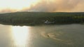 Firefighter helicopter draws water with scoop in pond to liquidate forest fire