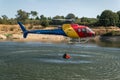 The firefighter helicopter filling the bucket at the lake