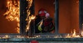 Firefighter hero carrying baby girl out from burning building area from fire incident. Rescue people from dangerous