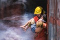 Firefighter holding child boy to save him in fire and smoke Firemen rescue the boys Royalty Free Stock Photo