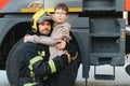 Firefighter holding child boy to save him in fire and smoke,Firemen rescue the boys from fire Royalty Free Stock Photo