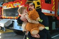 Firefighter holding child boy to save him in fire and smoke,Firemen rescue the boys from fire Royalty Free Stock Photo