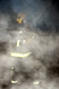 Firefighter hosing down and damping in a smoke filled building