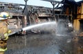 Firefighter pours water on trucks on fire