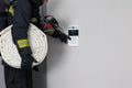 A firefighter in protective clothing, with fire extinguishing equipment, tries to open a closed door by dialing the intercom code Royalty Free Stock Photo
