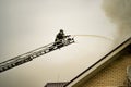 A firefighter puts out a burning building with height extension ladders