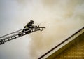 A firefighter puts out a burning building with height extension ladders