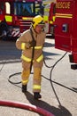 Firefighter runs out a hose at the scene of a fire.