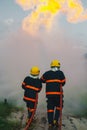 Firefighter spraying high pressure water to fire with copy space