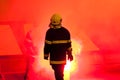 Firefighter standing in the torch smoke