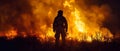 Firefighter stands in front of large wildfire