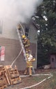 Firefighter take a hose line to second floor of a house on fire