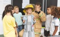 Firefighter teaching student about fire safety in classroom