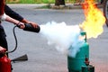 Firefighter teaching woman or man how to using fire extinguisher spraying form to fire