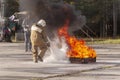 A fireman showing how to use a fire extinguisher on a training f Royalty Free Stock Photo