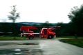 Firefighter truck driving fast on a wet road Royalty Free Stock Photo