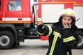 Firefighter in uniform using portable radio set near fire truck Royalty Free Stock Photo