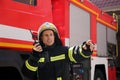 Firefighter in uniform using portable radio set near fire truck outdoors Royalty Free Stock Photo