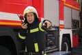 Firefighter in uniform using portable radio set near fire truck Royalty Free Stock Photo
