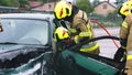 Firefighter using jaws of life to extricate trapped victim from the car