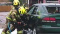 Firefighter using jaws of life to extricate trapped victim from the car