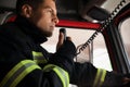 Firefighter using radio set while driving fire truck Royalty Free Stock Photo