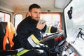 Firefighter using radio set while driving fire truck. Royalty Free Stock Photo