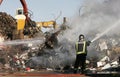 Firefighter working on industrial fire at junk yard