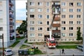 Firefighters in action, two men uprise in telescopic boom basket of fire truck. Some people are watching, block of flats in Royalty Free Stock Photo