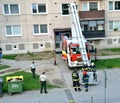 Firefighters in action, two of them get aboard into telescopic boom basket. Two police officers stand next to the fire truck