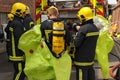 Firefighters in breathing apparatus don protective suits.