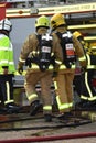 Firefighters in breathing apparatus with fire engine