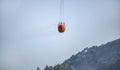 Firefighters bringing water from the ocean to a wildfire burning a forest of trees on a mountain. Royalty Free Stock Photo